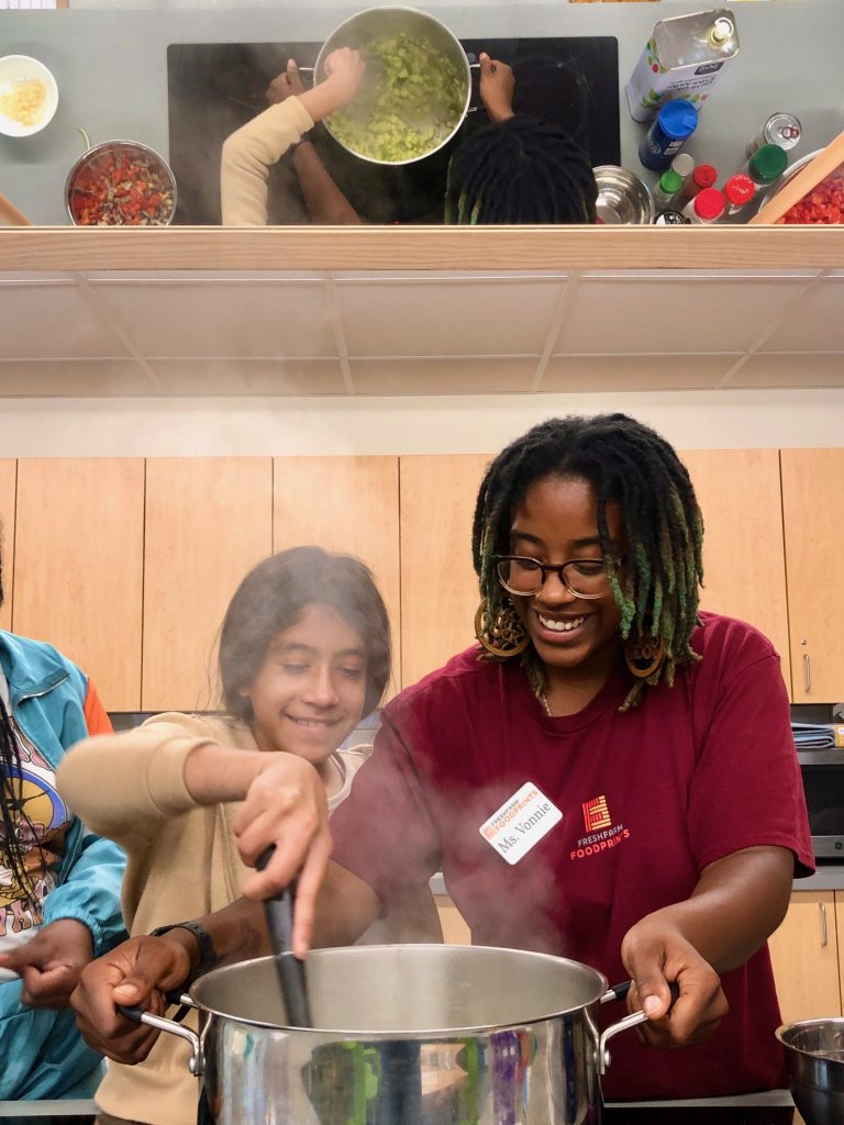 FoodPrints student cooking with an instructor in a teaching kitchen