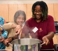 FoodPrints student cooking with an instructor in a teaching kitchen