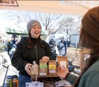 A Grain Stand Specialist helping a shopper select locally grown grains.