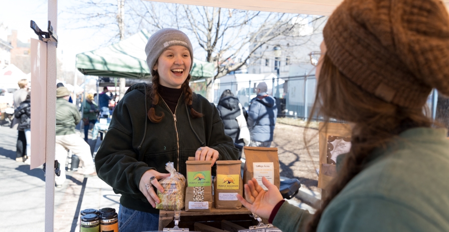 A Grain Stand Specialist helping a shopper select locally grown grains.