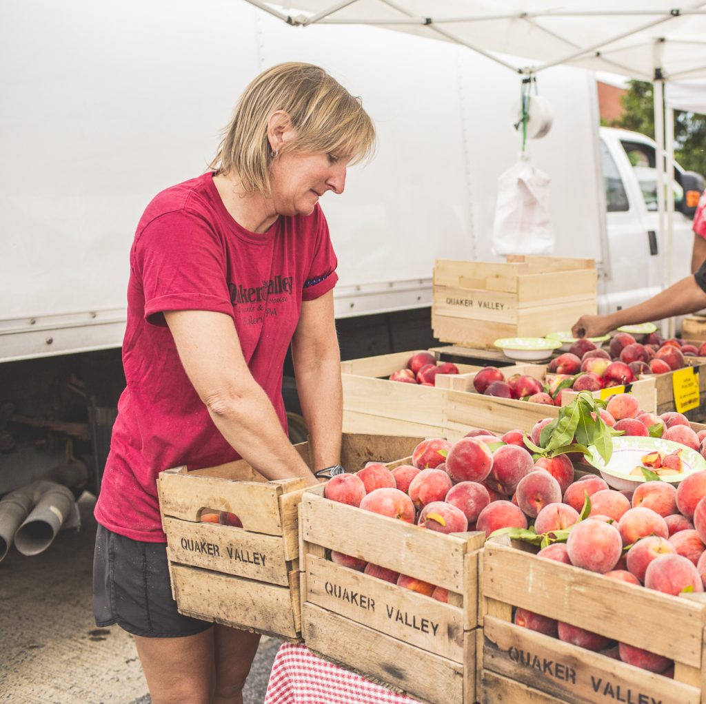 Fredi Schulteis of Quaker Valley Orchard unloading peaches at a farmers market